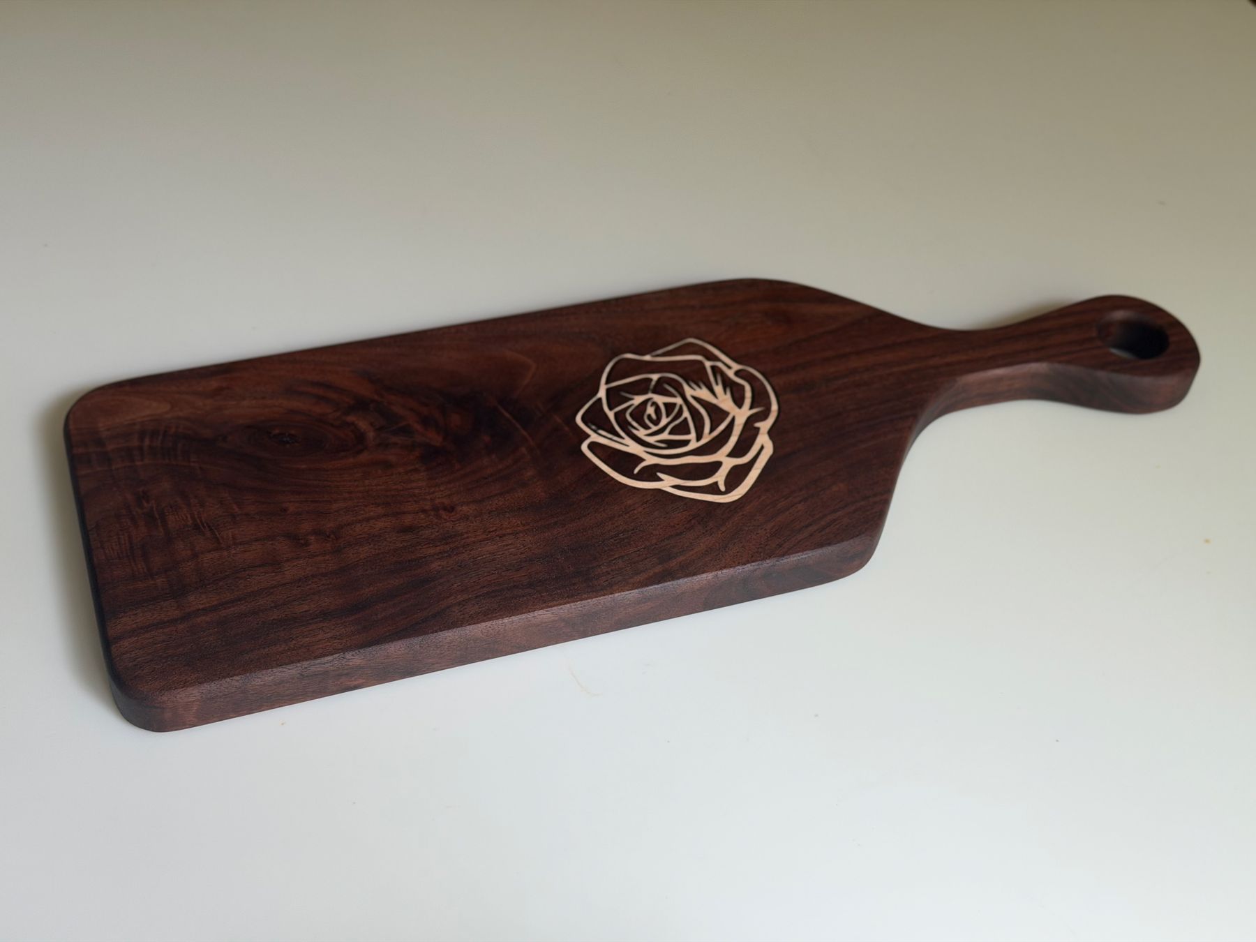 Walnut serving board with a maple rose inlay