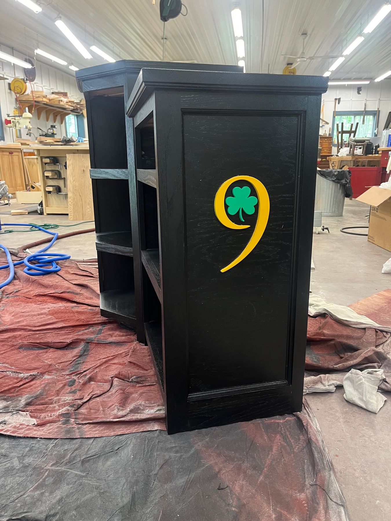 Black restaurant host stand with a painted shamrock emblem