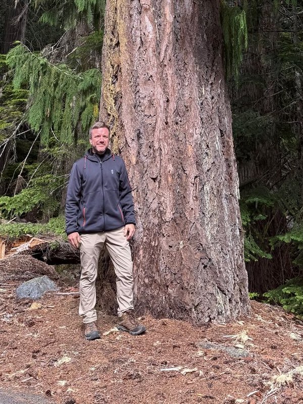 Matthew Fuller Rose standing at the base of an old-growth tree